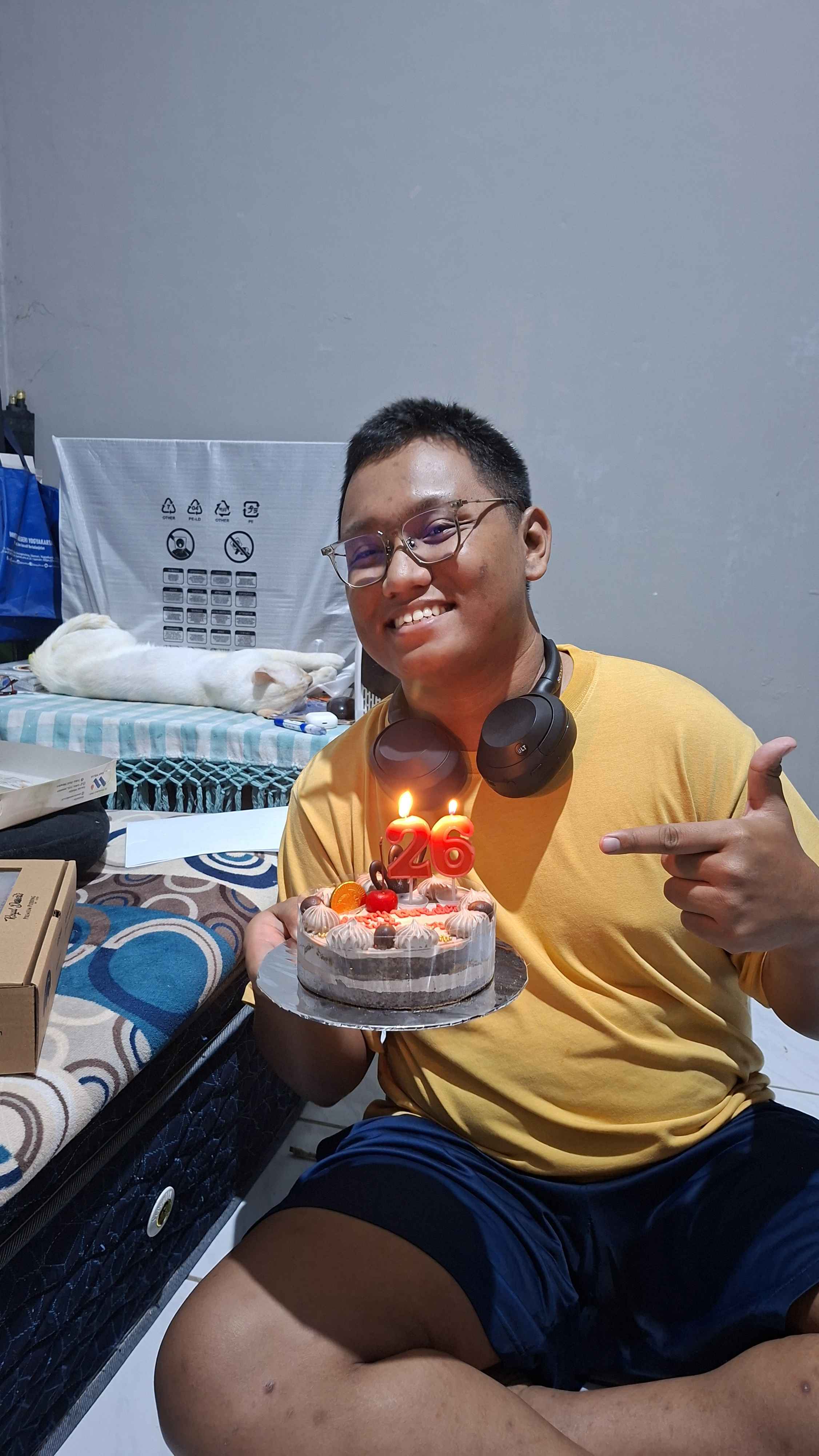 Midnight on my 26th birthday, holding a small tart cake with Casper
